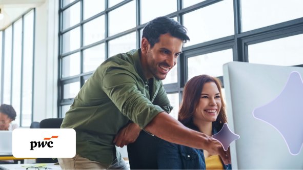 Homem e mulher sorrindo em frente à tela do computador